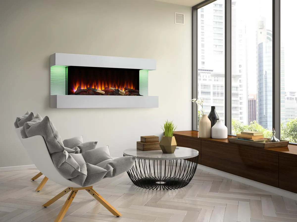 Electric fireplace with floating mantel and accent lighting in minimalist living room with windows overlooking skyscrapers.